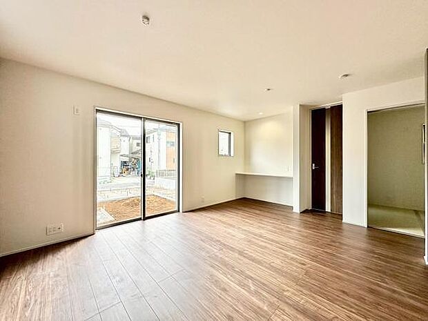 (LDK18.25帖)リビングには大きな窓があり採光がしっかりと確保されています。木目調の床が温かみを感じさせる空間です。