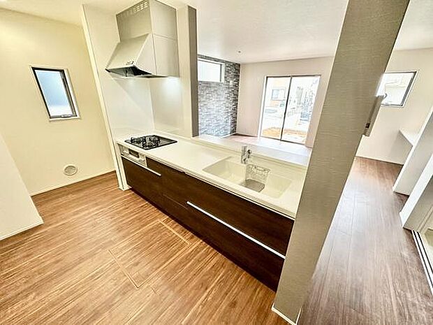 明るい色合いの床とシンプルなデザインがキッチン空間を広く見せています。窓から自然光が入りやすく換気も良好です。カウンタータイプで作業動線もスムーズに確保されています。