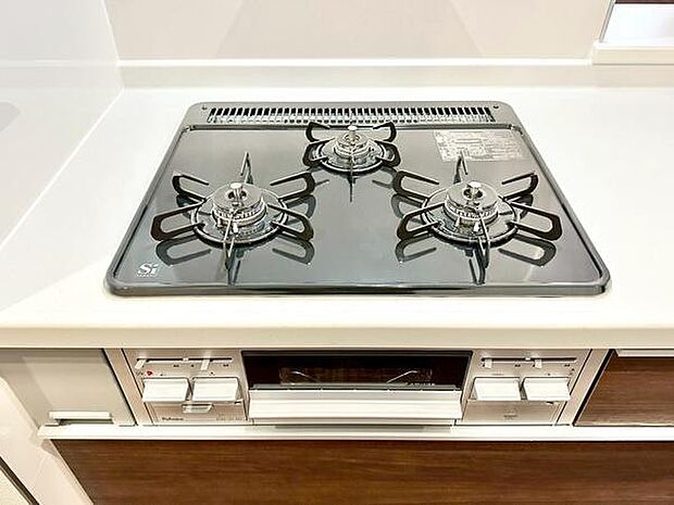 三口コンロが設置されているため複数の調理が同時に行えます。清潔感のあるキッチンでガスコンロも使いやすい設計です。シンプルな操作パネルが手元に配置されています。