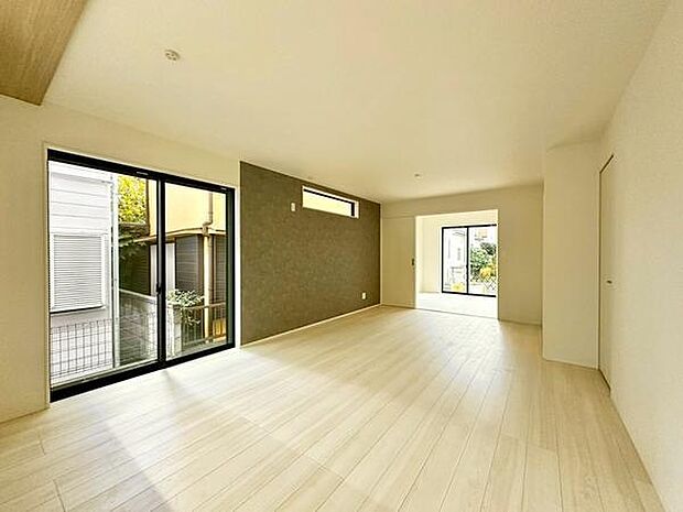 【17.5帖LDK】明るい陽射しが差し込むリビングは清潔感のある白い壁とナチュラルなフローリングが特徴です。折下げ天井とアクセントクロスが空間にメリハリをプラス。