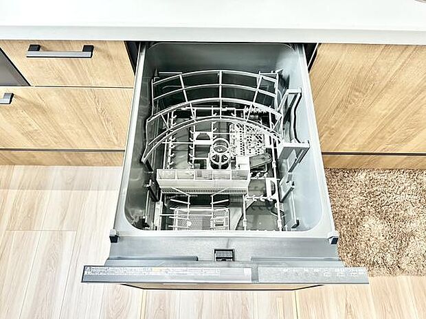 キッチンにはビルトインタイプの食器洗浄機が備わっています。引き出し式で使い勝手に配慮された設計です。木目調の収納と調和が取れたデザインになっています。手入れも簡単な仕様です。