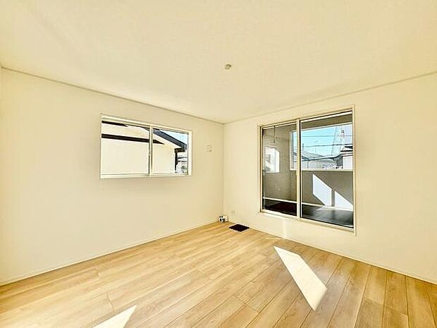 【8帖】寝室には大きな窓があり自然光がしっかりと入ります。床は明るい色合いで空間が広く感じられます。バルコニーへの出入りができるスライドドアも設置されています。シンプルな内装が特徴です。