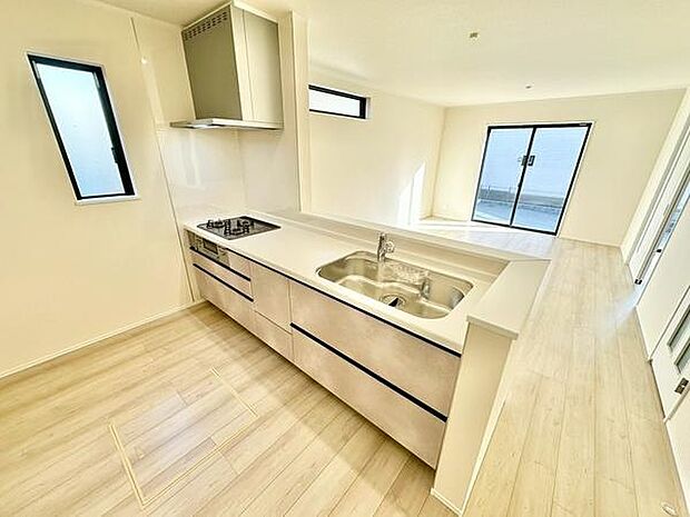 明るい色味の床と壁で空間全体が開放的な印象のキッチンです。窓が2つあり自然光がたっぷり入りやすい設計です。シンプルなデザインで清潔感が際立っています。広くフラットな作業スペースも特徴です。