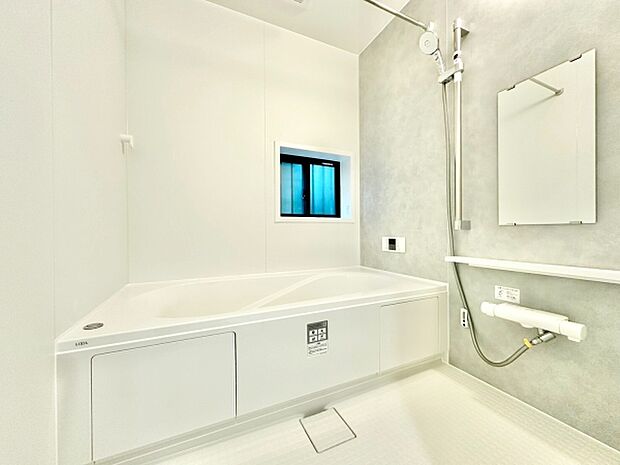 爽やかな色合いが特徴のバスルームです。窓からの採光で浴室内が明るく保たれています。広々とした浴槽で快適に利用できます。シンプルなデザインで清潔感があります。機能的な設備も揃っています。