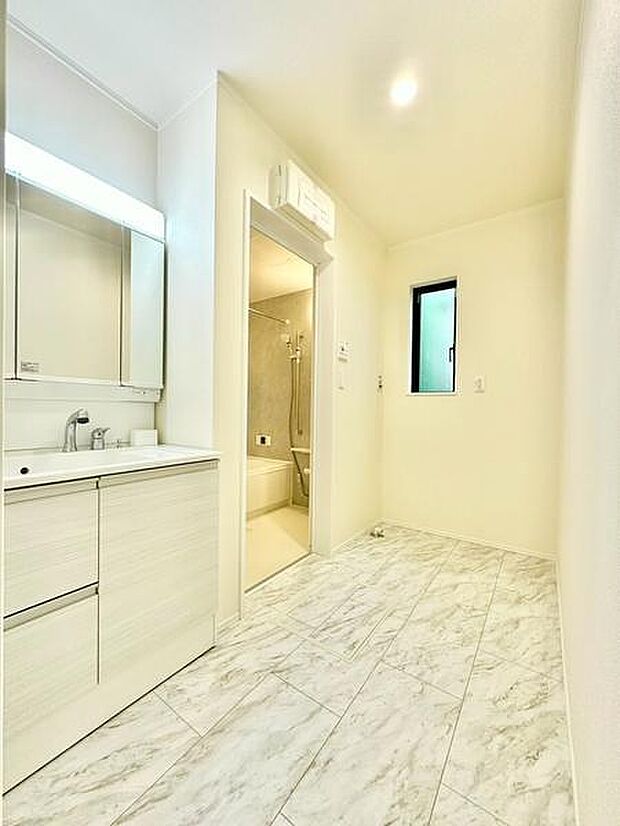 明るく清潔感のある洗面所が魅力です。大きな鏡と収納力のある洗面台が便利に使えます。お手入れしやすい床材が採用されています。浴室への動線もスムーズです。窓が採光と換気に役立ちます。