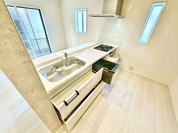 明るい空間が広がるキッチンです。大きな窓からは自然光がたっぷり差し込みます。収納スペースがしっかりと確保されています。シンプルでスタイリッシュなデザインが特徴です。