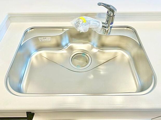 広々としたシンクが特徴のキッチンです。ステンレス製で清潔感があります。蛇口もシンプルなデザインで使いやすさを感じます。スペースに余裕がありお手入れも簡単です。