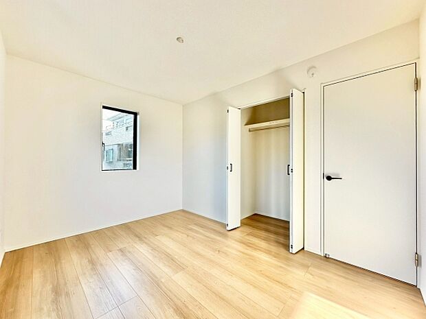 【6帖洋室】ナチュラルなフローリングで空間が広々としています。白を基調とした内装が清潔感を感じさせます。収納スペースもしっかり確保されています。