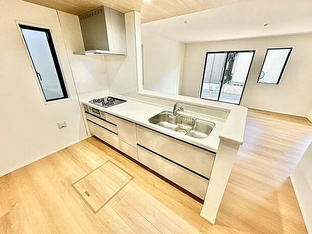 明るい空間に溶け込むキッチンが特徴です。シンプルなデザインで清潔感があります。対面カウンターが開放的な印象を演出しています。収納スペースも豊富で機能的です。キッチンからリビングへの見通しが良好です。