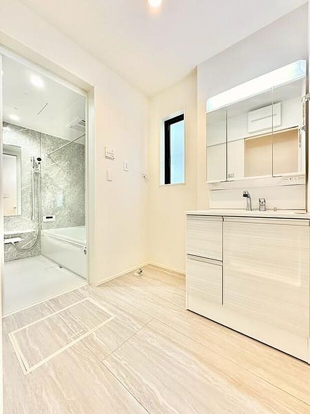 明るい空間に設計された洗面所はシンプルで清潔感があります。洗面台の収納力もあり整理整頓しやすい印象です。床や壁の色合いが統一され室内全体がすっきりとしています。浴室への動線もスムーズで便利に使えます。