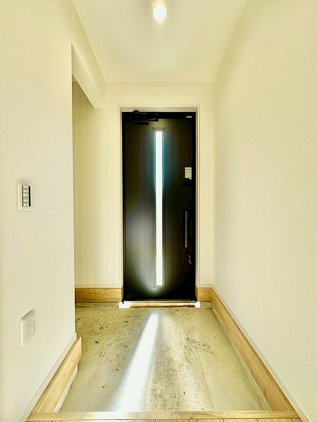 明るい光が差し込む玄関は清潔感のあるシンプルなデザインです。天井まであるドアが圧迫感を感じさせません。無駄のないスペースがスマートな印象を与えます。木目の床と白い壁が調和しています。