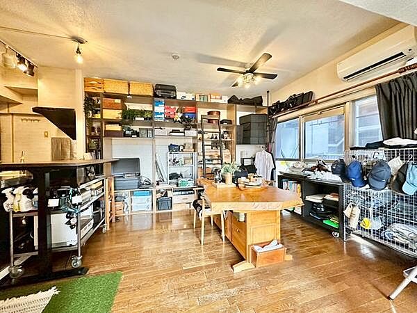 広々としたリビングには大きな窓があり自然光がたっぷり差し込みます。壁面収納が充実しており整理整頓しやすい空間です。木目調の床が温かみを演出しインテリアの自由度も高く感じられます。