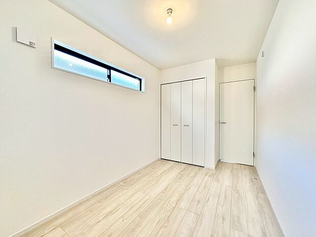 (洋室5.2帖）スリット窓が自然光を採り入れ室内を爽やかに演出します。クローゼットも備わっておりすっきりとした印象を与えます。白を基調とした清潔感ある空間です。