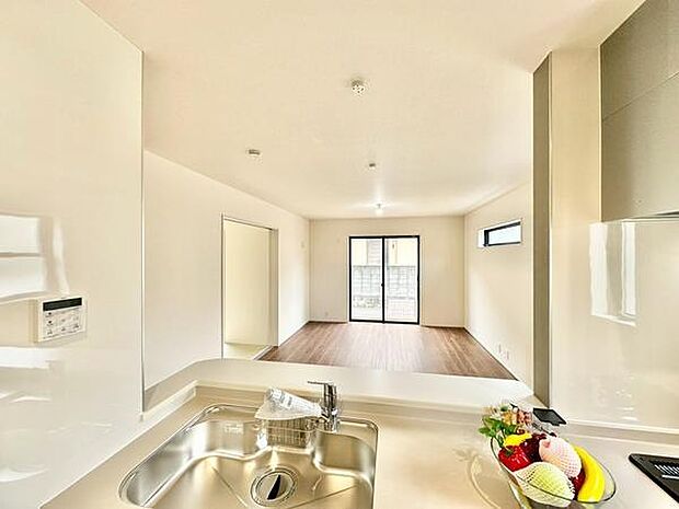 明るく開放感のある空間が広がっています。窓からの自然光がリビング全体をやさしく照らします。白を基調とした内装で清潔感があります。キッチンからリビングが見渡せる間取りです。