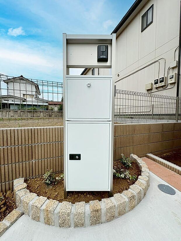 宅配ボックスが設置されているため不在時でも荷物の受け取りができて便利です。シンプルなデザインで周囲と調和します。設置場所がしっかり整備されていて管理もしやすい印象です。植栽スペースも整えられています。