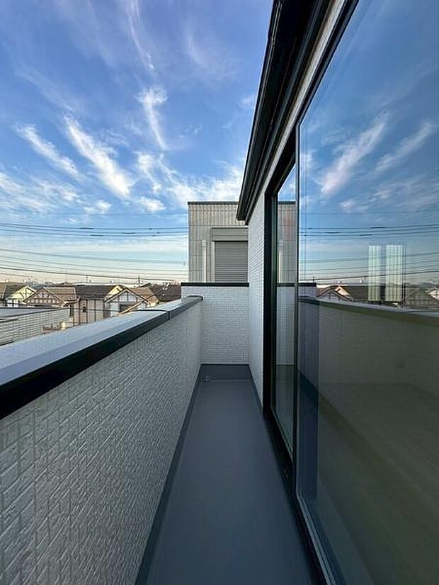 広々としたバルコニーは開放的な空間を演出しています。空を望む眺望が魅力的です。日差しが差し込む明るいバルコニーとなっています。壁や手すりはシンプルなデザインで清潔感があります。