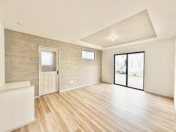 木目調のフローリングが爽やかな印象を与えます。大きな窓から光が差し込み室内が明るく開放的です。アクセントウォールのデザインがモダンな雰囲気を演出しています。