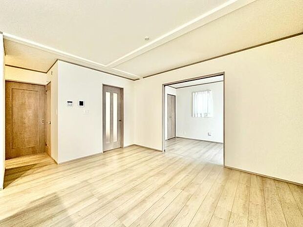 【18.37帖】明るい床材とシンプルな壁が調和したリビングです。隣接するお部屋への動線もスムーズで空間に広がりを感じられます。大きな窓から自然光がたっぷりと入ります。