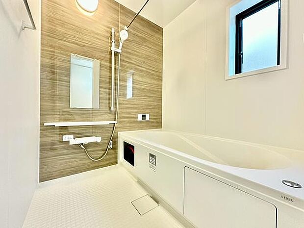 壁面のデザインがアクセントとなっているバスルームです。大きな窓があり採光も確保されています。浴槽とシャワーが分かれており使いやすい空間となっています。シンプルな内装で清潔感があります。