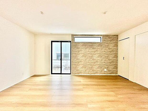 【16帖】明るい光が差し込むリビングです。アクセントクロスが印象的な広々とした空間です。窓からの自然光が室内をやさしく照らします。