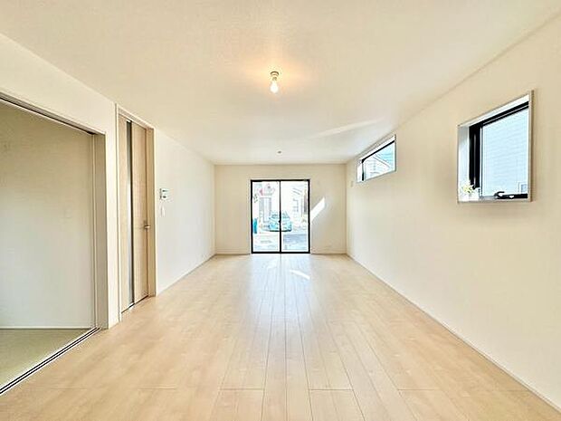 【18帖】リビングはシンプルで開放感のある空間です。大きな窓から自然光がしっかりと入ります。無駄のない設計でお手入れもしやすいです。明るい床材が清潔感を演出しています。ゆとりのある間取りです。