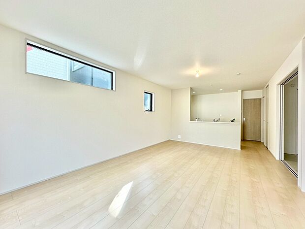 【18帖】リビングは明るい色調のフローリングが特徴的です。二つの窓から自然光がたっぷりと入り室内を爽やかに演出します。ダウンライトが空間に柔らかさを添えています。