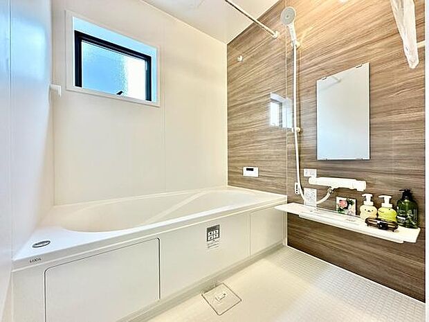 浴室には窓があり自然光が差し込む明るい空間です。アクセントパネルがスタイリッシュな印象を与えます。洗い場も広々としており使い勝手が良いです。収納スペースも設けられており小物の整理に便利です。