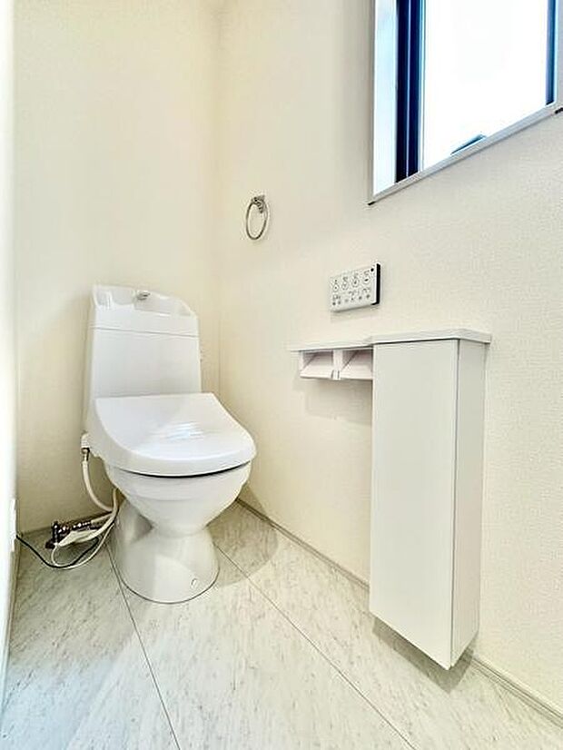 明るい空間が広がるトイレです。窓付きで換気がしやすく清潔感があります。操作パネルが壁に設置されており使いやすいです。収納スペースも確保されています。