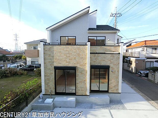 外観は明るい色合いの壁材が印象的です。窓の配置がバランスよく採光にも配慮されています。道路からのアプローチもスムーズで開放感があります。庭や駐車スペースも広く感じられる外観です。