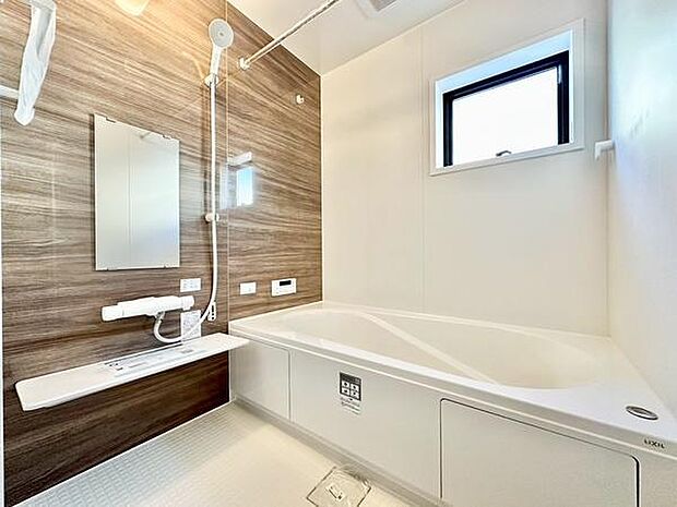 落ち着いた色合いのバスルームで、窓から自然光が入り明るさを感じられます。ゆとりある浴槽でゆったりくつろげ、壁面デザインがアクセントとなった清潔感のある空間です。