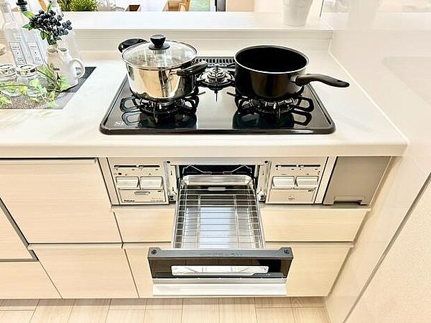 二口ガスコンロと広めのグリルを備え、さまざまな調理に対応できるキッチン。収納も充実しており、周りをすっきり保てます。