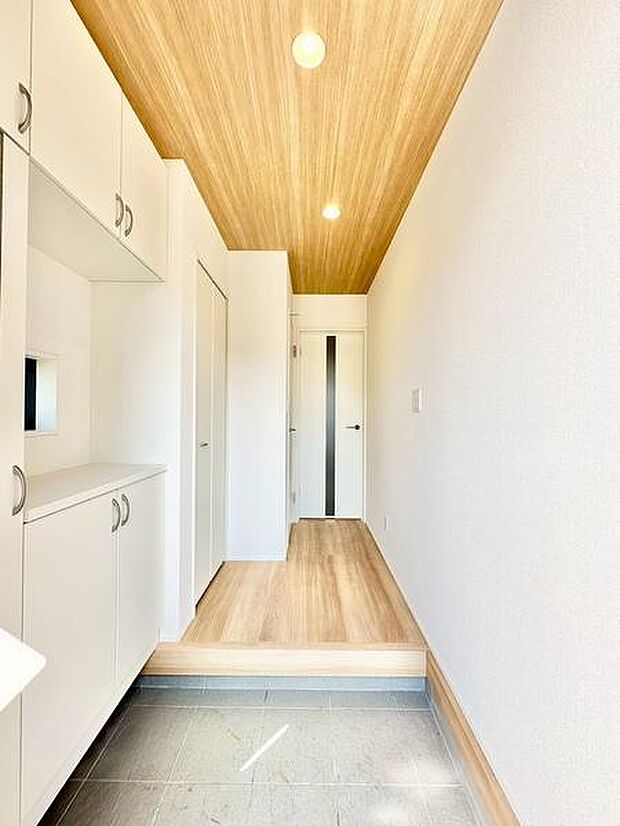 玄関スペースは明るく開放的な印象で、白を基調としたデザインが清潔感を演出しています。収納も備わっており、整理整頓がしやすい設計です。