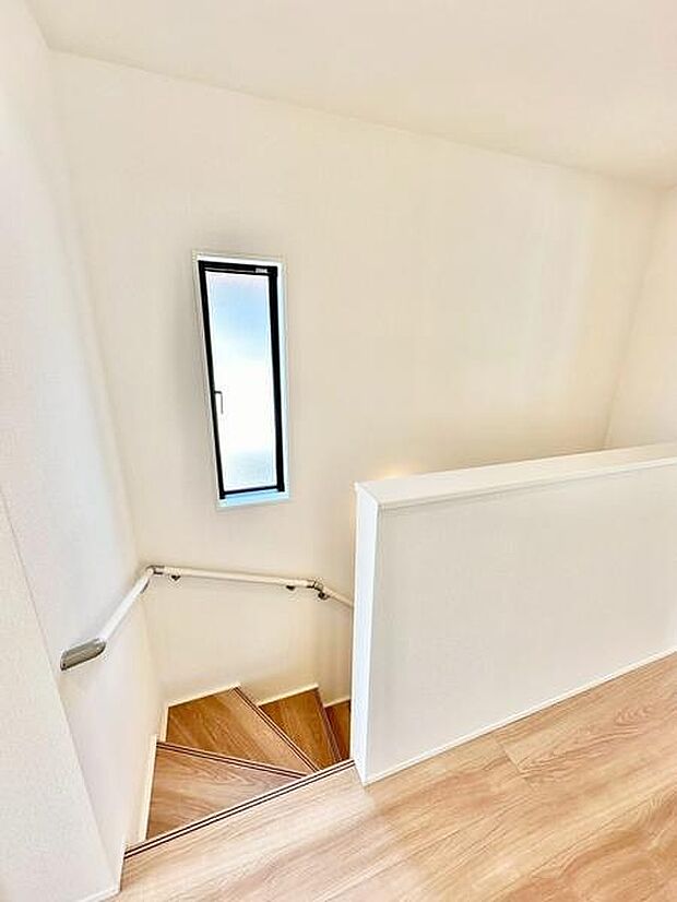 採光用の小窓から光が差し込む明るい階段。手すり付きで、ご家族みんなが安心して使える設計です。