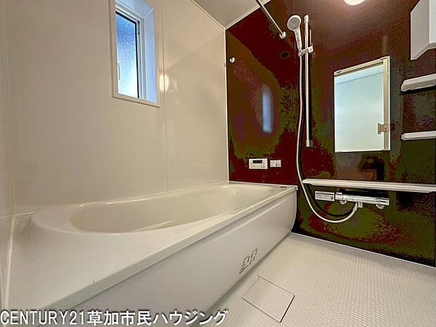 落ち着いた色合いのパネルがアクセントのバスルームです。窓から明るさを取り入れられ、浴槽とシャワーが独立しているため使い勝手も良好。収納棚や鏡も備わり、日々の利用に便利な空間です。