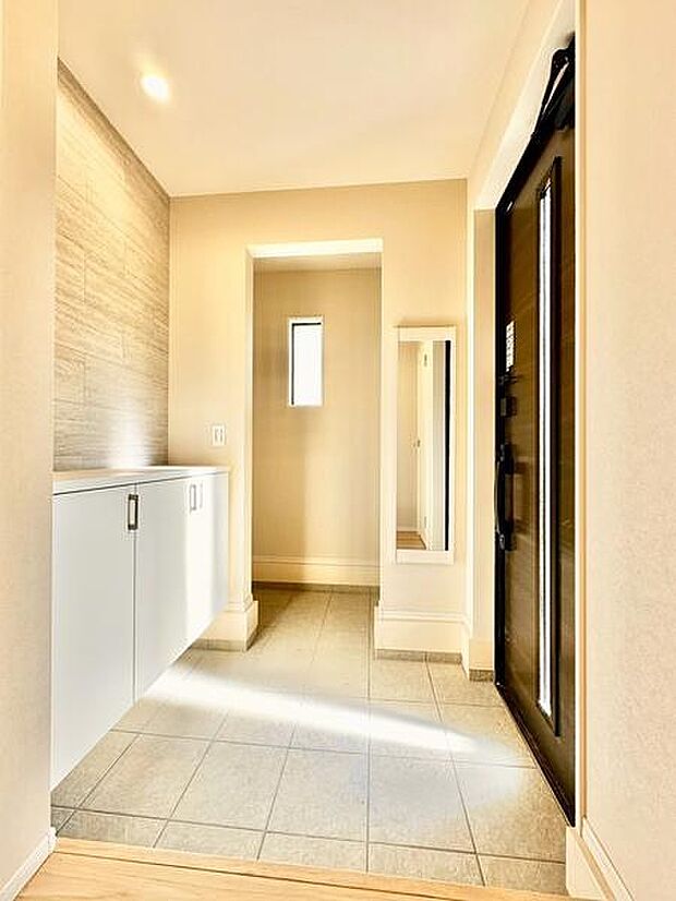 明るさを感じる玄関で清潔感があります。収納スペースが備わっており整理整頓しやすい印象です。シンプルなデザインで使いやすさが考えられています。小窓から自然光が入り開放的な雰囲気です。