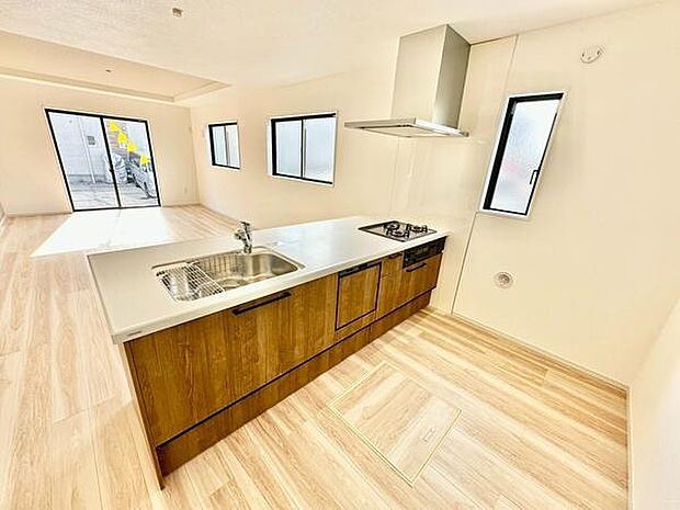 明るく開放感のあるキッチンです。ウッド調のデザインが空間に温かみをプラスしています。窓が多く自然光がしっかり入ります。シンプルですっきりとした印象です。リビングとのつながりも魅力です。