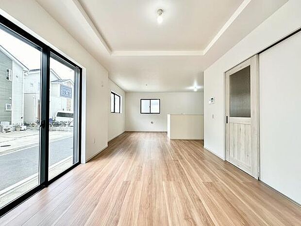 【19.3帖LDK】明るいフローリングが広がるリビングです。大きな窓からは自然光がしっかり入ります。室内はすっきりとした印象で新しい生活にぴったりです。シンプルな内装が家具の配置もしやすい空間です。