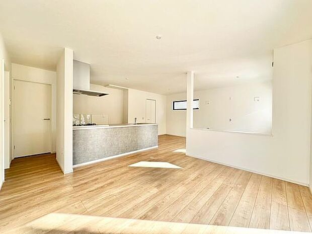 【20.9帖LDK】大きな窓から自然光が入るリビングで空間全体が明るく開放的です。木目調のフローリングが温かみを感じさせます。キッチンとのつながりも良く使い勝手の良さが魅力です。