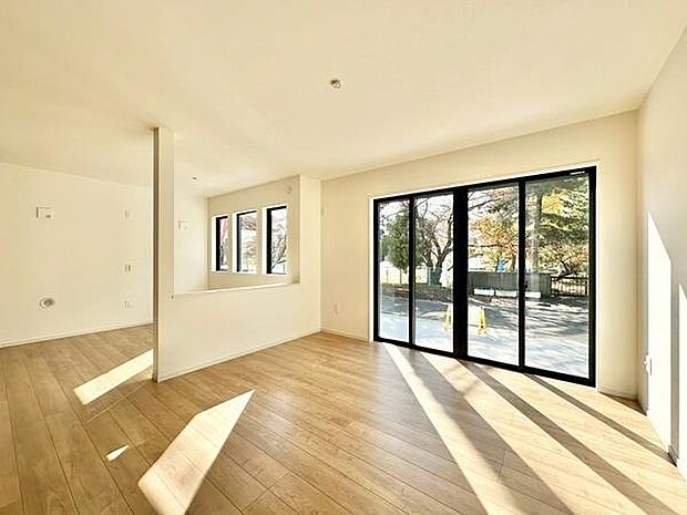 【20.9帖LDK】リビングは大きな窓から豊かな自然光が入り室内が明るく感じられます。シンプルな内装でどのようなインテリアにも合わせやすい雰囲気です。床は木目調で温かみがあり空間全体が開放的です。