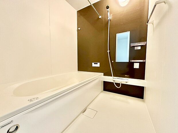 白を基調とした落ち着いたデザインの浴室です。壁面のアクセントカラーが空間を引き締めています。シャワーと鏡収納棚があり便利に使えます。バスタブも広々としています。