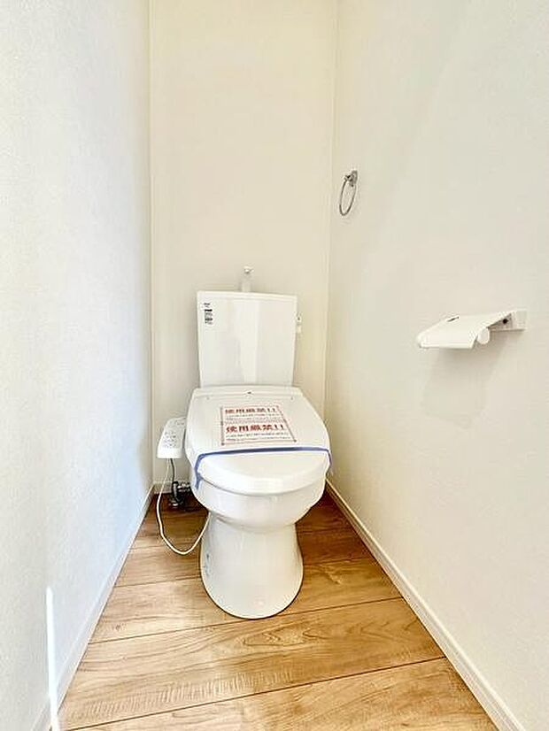 明るい空間が印象的なトイレです。床材と白を基調とした内装が清潔感を演出しています。ペーパーホルダーやタオルリングも設置済みで機能的な仕様となっています。