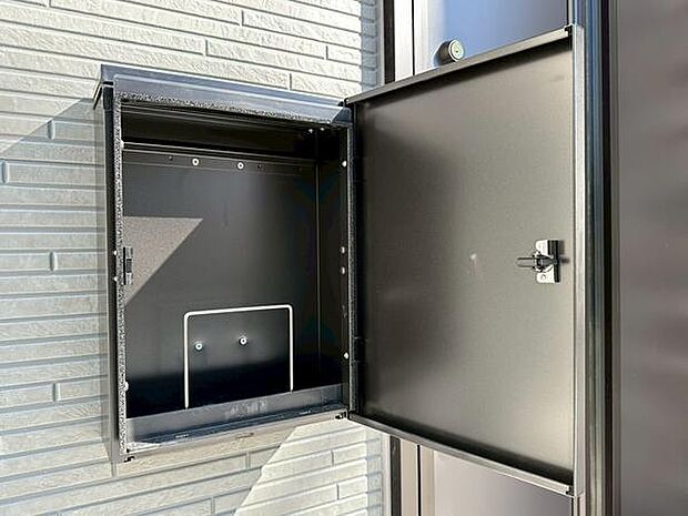 スタイリッシュなデザインの宅配ボックスが設置されています。外壁と調和したカラーが印象的です。扉の開閉もスムーズで利用しやすい仕様です。シンプルな造りで日常使いに便利なポイントです。