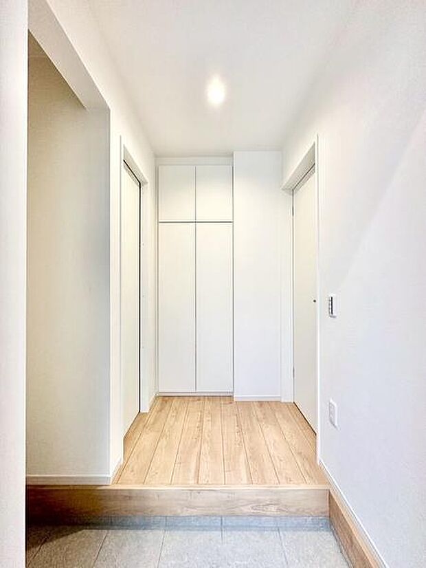 玄関はホワイトを基調としたすっきりとした印象です。収納スペースが豊富に確保されています。床材と壁のコントラストが空間を引き立てています。清潔感のあるデザインが魅力です。