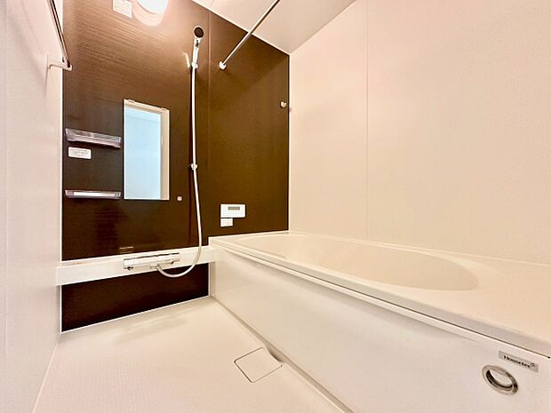 落ち着いた色合いのバスルームです。壁面のアクセントカラーが空間を引き締めます。清潔感のある仕上がりで手入れも簡単です。使い勝手の良い浴槽が備わっています。