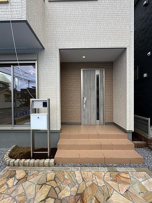 壁に囲まれた奥まった玄関が、住まいに安心感と落ち着きを演出。屋根も設けられているため、雨風を受けにくく、天候を気にせず出入りしやすい設計です。