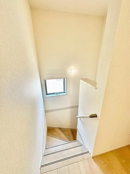 階段には窓を設け、自然光が差し込む明るい空間を演出。手すりも備えられており、昇り降りをしっかりサポートする安心設計です。