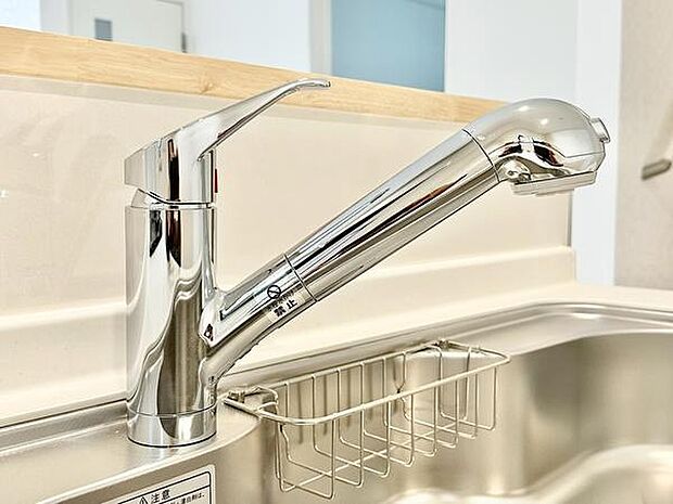 シンプルで手入れしやすいキッチンの水栓です。ヘッド部分が伸ばせるので使い勝手がよく洗い物もしやすい仕様になっています。水回りが清潔に保たれています。収納バスケットも付いていて利便性が感じられます。