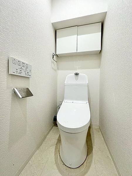清潔感のある白を基調としたトイレ空間です。収納棚が設置されており日用品の整理に便利です。壁面には操作パネルが配置されていて機能性にもこだわっています。