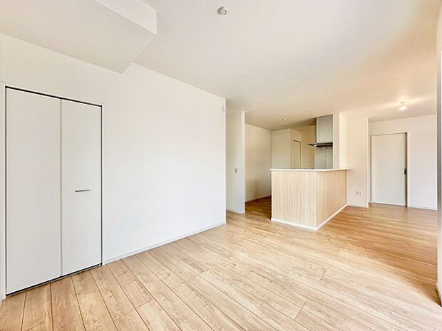 明るい木目調のフローリングが特徴的なリビングです。クローゼットが備わっており収納にも便利です。対面式のキッチンが空間に調和しています。室内全体がナチュラルな雰囲気でまとまっています。