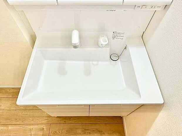 シンプルなデザインの洗面台は清潔感がありお手入れしやすい印象です。収納スペースも確保されており日常使いに便利です。白を基調としたカラーで空間が明るく感じられます。床面との調和が取れた雰囲気です。